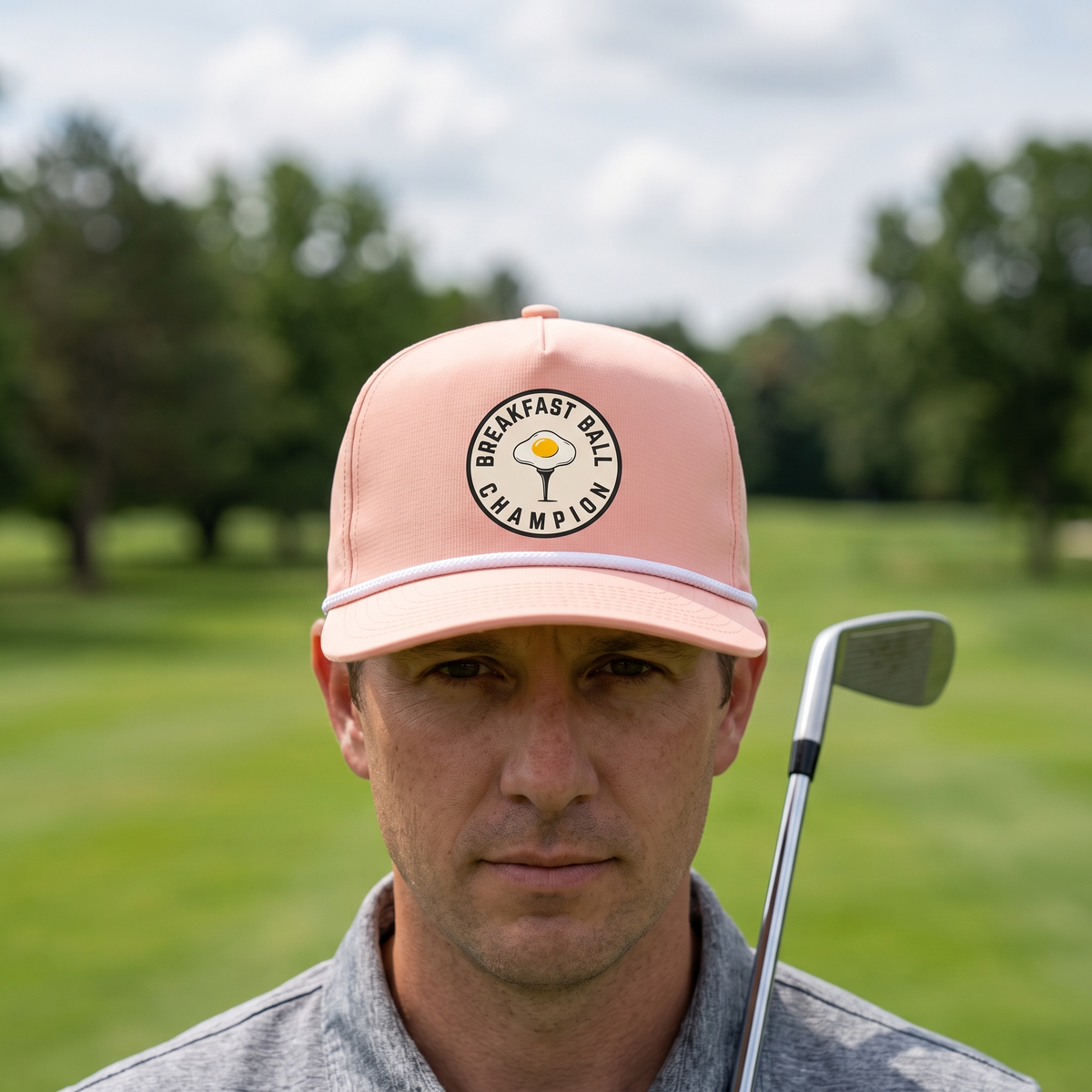 A golfer on a golf course wearing the Breakfast Ball Champion rope hat in Peachy with a white rope.