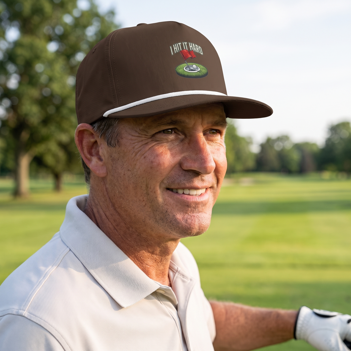 A golfer on a golf course wearing the I Hit It Hard rope hat in Espresso with a white rope.