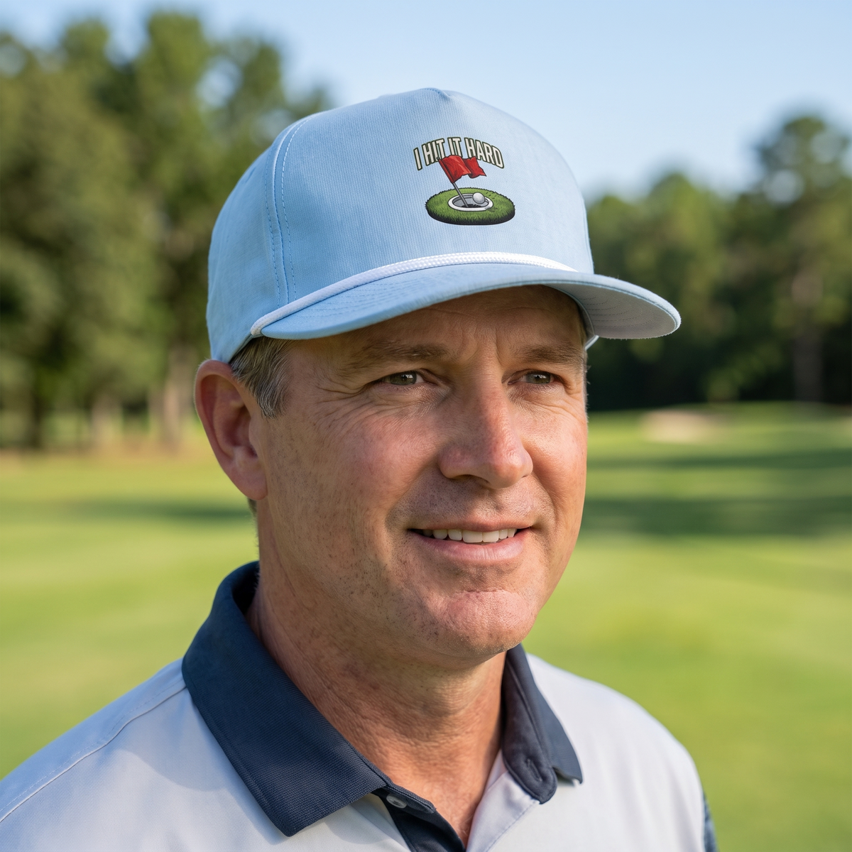 A golfer on a golf course wearing the I Hit It Hard rope hat in Chambray with a white rope.