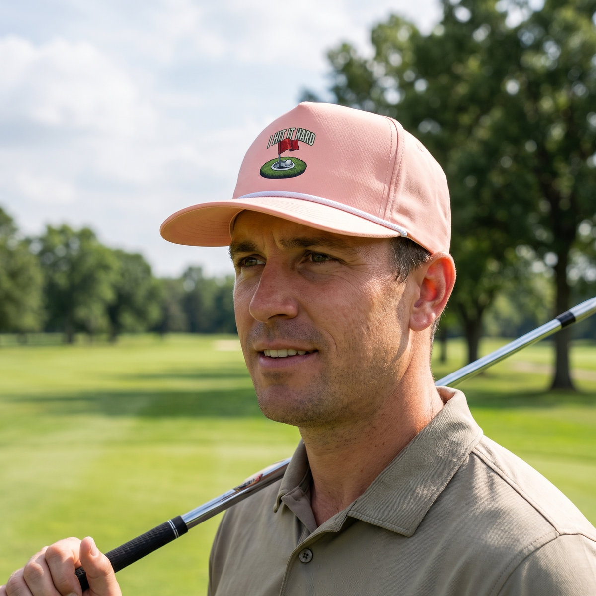 A golfer on a golf course wearing the I Hit It Hard rope hat in Peachy with a white rope.