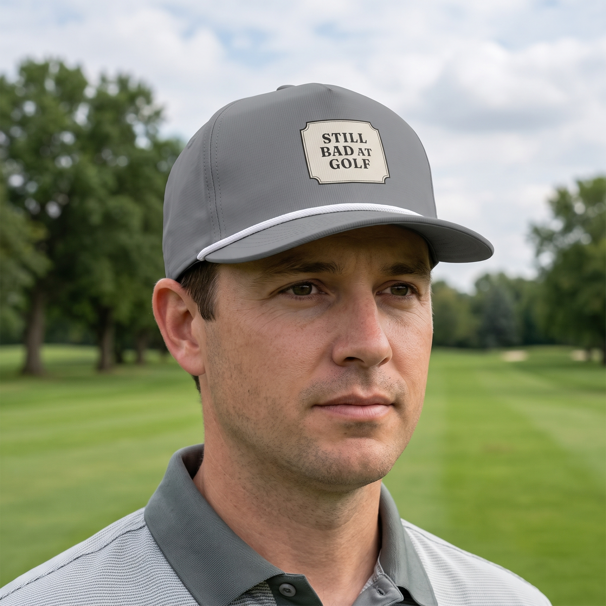 A golfer on a golf course wearing the Still Bad at Golf rope hat in Granite with a white rope.